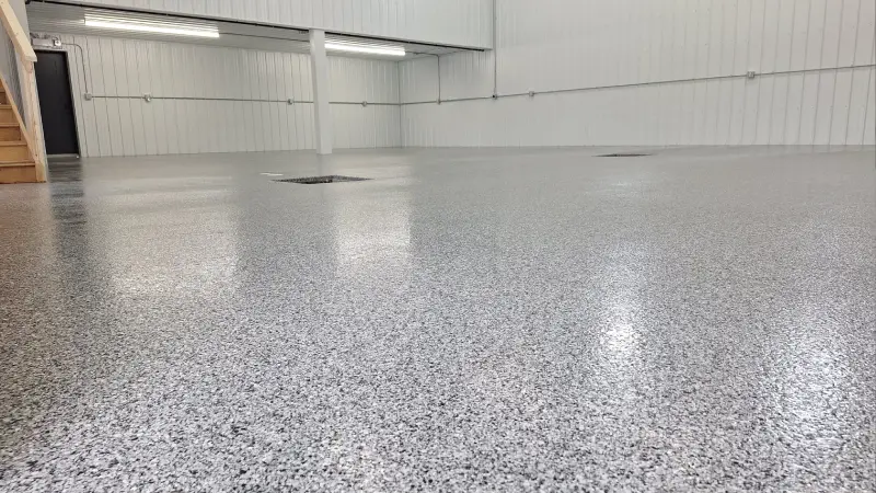 A professional polyaspartic floor coatings installation in a spacious, modern industrial facility.